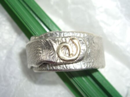 Wickelring mit Goldauflage Geschmorter Wickelring mit einer Auflage aus 333er Gold. Breite 12 mm. Die Ringgroesse ist 71.